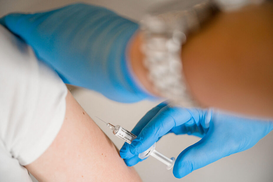 A patient receives a vaccination from a healthcare professional