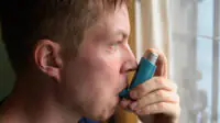 A man uses a pressurised-metered-dose inhaler