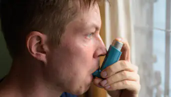 A man uses a pressurised-metered-dose inhaler