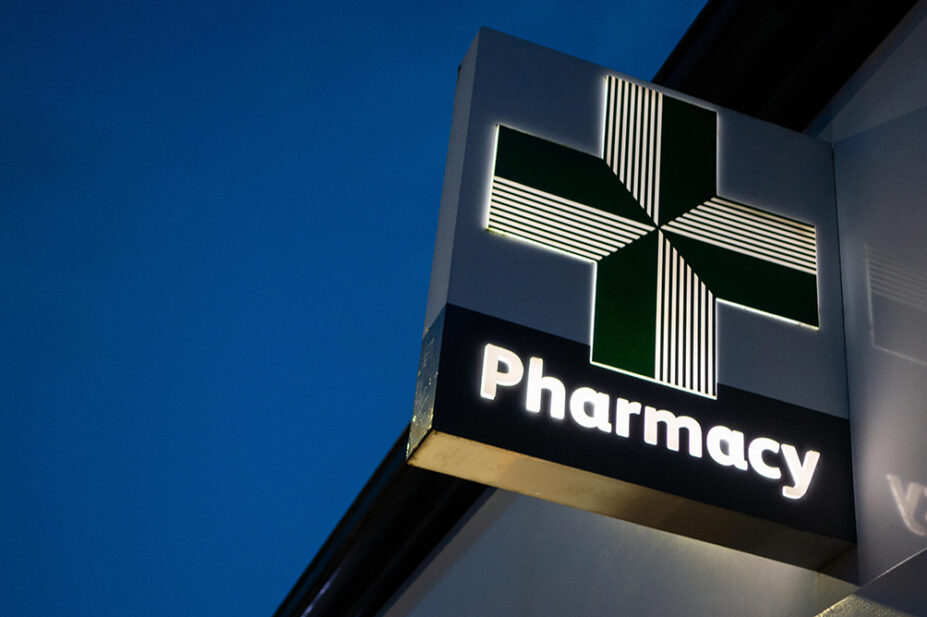 An image of a community pharmacy's illuminated sign at night