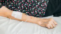 An older woman receives an intravenous treatment