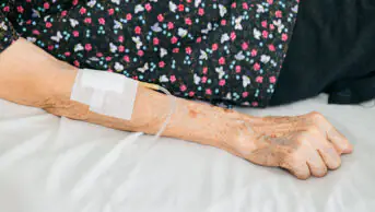 An older woman receives an intravenous treatment