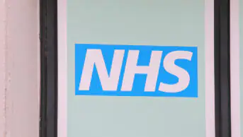 An image of the NHS logo outside one of its buildings