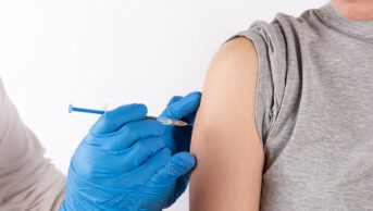 A young person receives a vaccine from a healthcare professional
