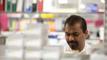 Asian pharmacy worker in dispensary