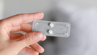 Woman holding blister pack of emergency hormonal contraception