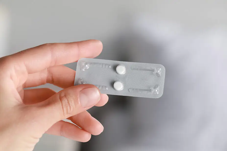 Woman holding blister pack of emergency hormonal contraception