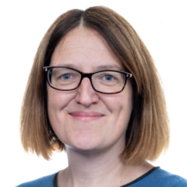 Catherine smiles wearing glasses and a blue top in front of a white background