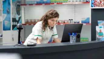 Pharmacist on computer in dispensary