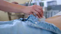 Physician carrying out scan on middle aged woman
