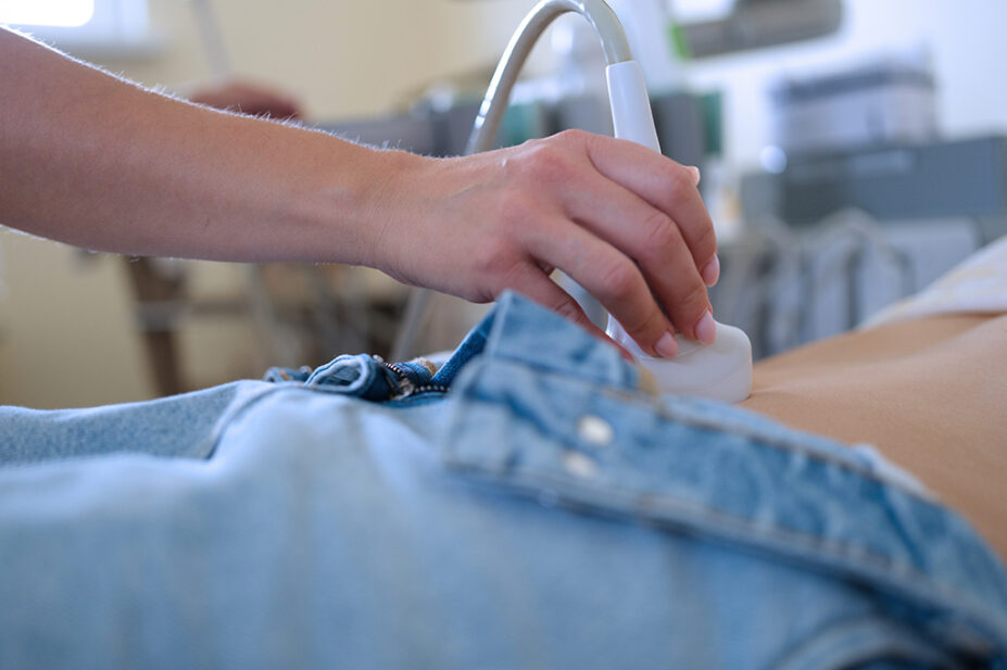 Physician carrying out scan on middle aged woman