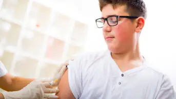 A teenager receives a vaccination