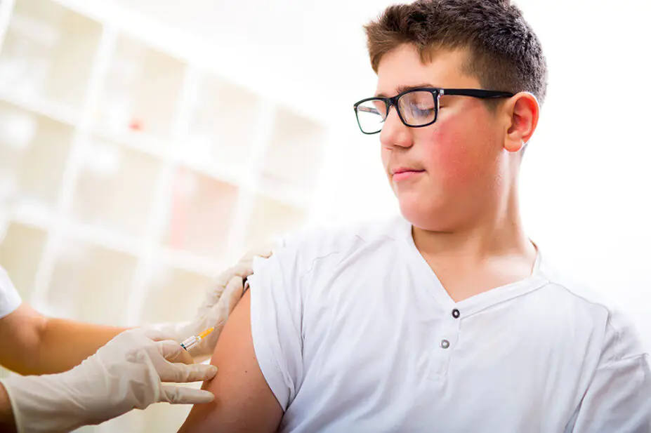 A teenager receives a vaccination
