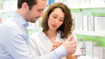 A pharmacist assists a patient in a community pharmacy