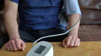 A man checks his blood pressure at home
