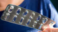 A person holds an empty blister pack of medicine