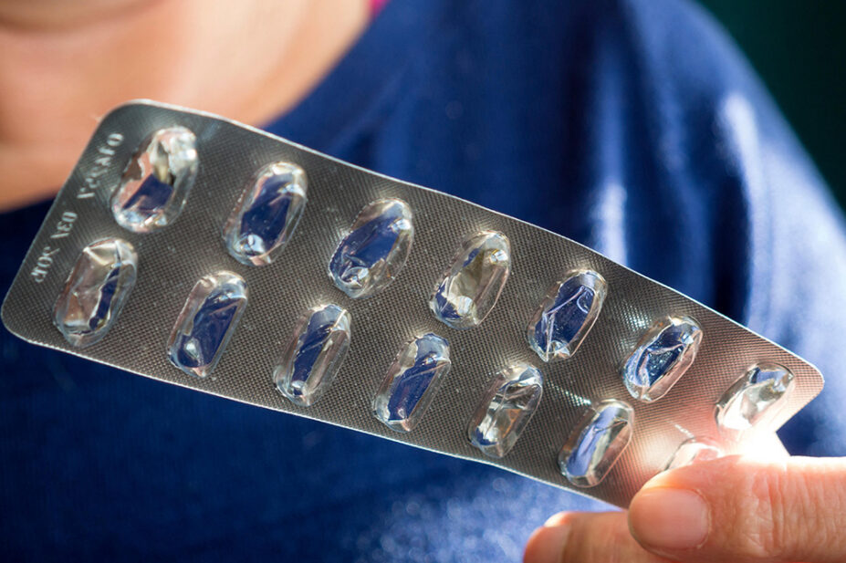 A person holds an empty blister pack of medicine