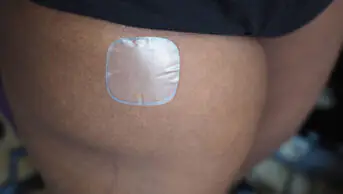 An image of a hormone replacement therapy patch on a woman's thigh