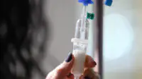 A healthcare professional prepares an intravenous infusion