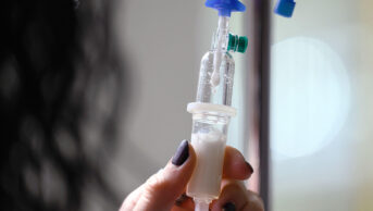 A healthcare professional prepares an intravenous infusion