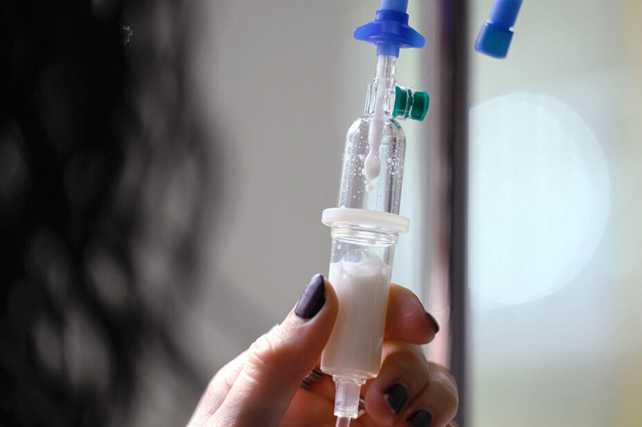 A healthcare professional prepares an intravenous infusion