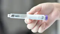 A woman holds a weight-loss pen