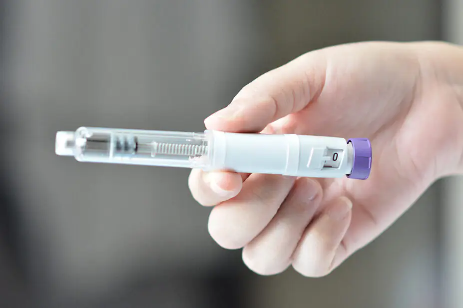 A woman holds a weight-loss pen