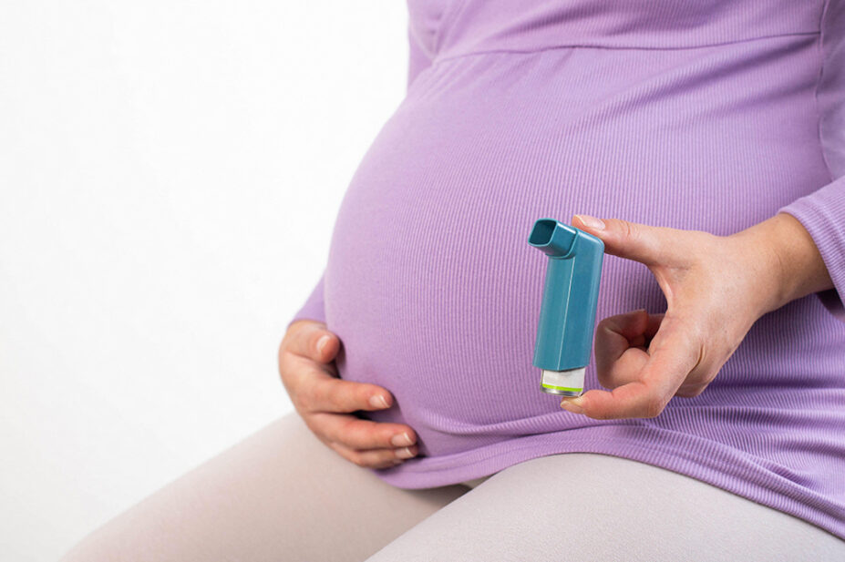 A pregnant woman holds an inhaler