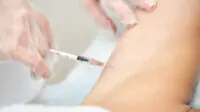 A woman receives a vaccine injection