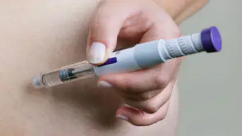 A man injects himself with a weight-loss pen