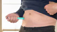 A man injects himself with a weight-loss pen