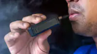 A man smokes a vape