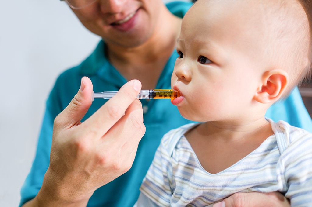 Doctor feeds baby oral medicine