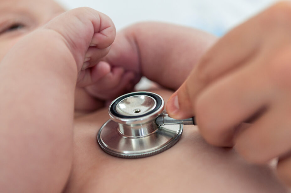 Doctor listens the heart to small newborn with stethoscope
