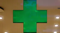 A green cross sign in a community pharmacy