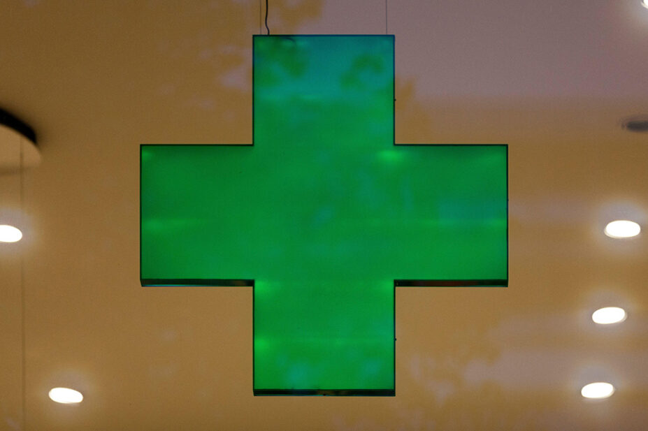 A green cross sign in a community pharmacy