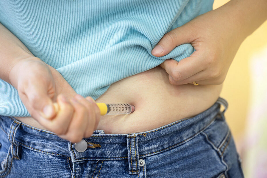 A person injects a weight loss pen into their abdomen