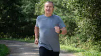 An older man runs outside for exercise