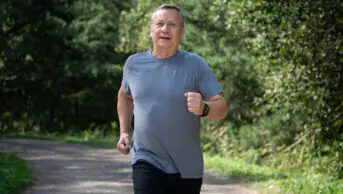 An older man runs outside for exercise
