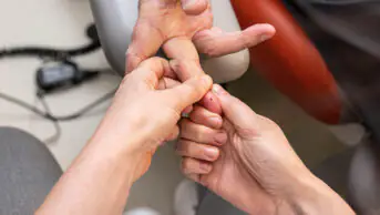 A patient undergoes a finger prick test for cholesterol