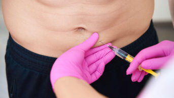 A man receives an injection in his abdomen
