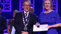 Tracey Thornley accepts her International Pharmaceutical Federation Fellowship from Paul Sinclair, president of the International Pharmaceutical Federation