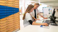 A pharmacist helps a trainee pharmacist