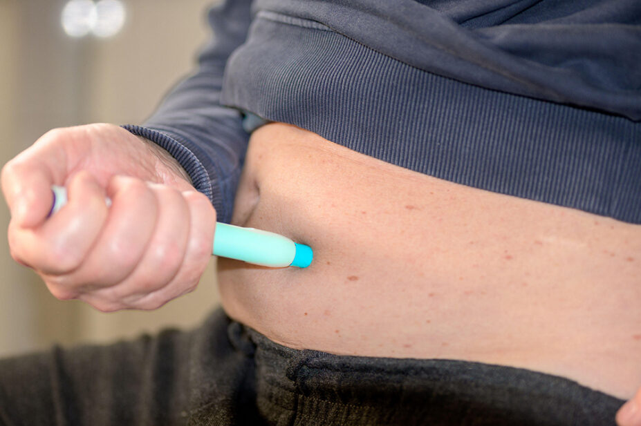 A man injects himself in the abdomen with a weight-loss pen