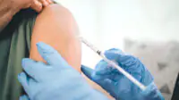 A person receives a vaccination in their upper arm