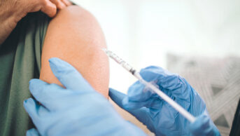 A person receives a vaccination in their upper arm