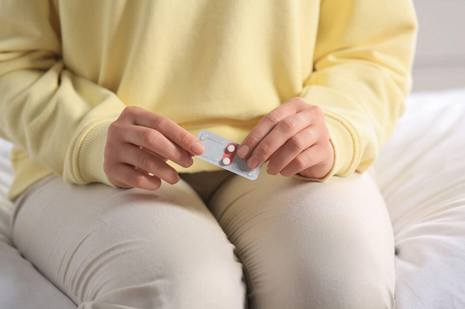 A woman holds a blister pack of emergency contraception