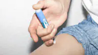 A man injects a weight-loss pen into his thigh