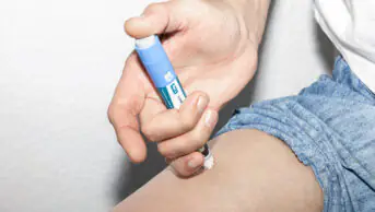 A man injects a weight-loss pen into his thigh