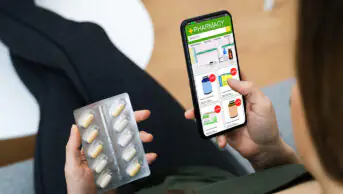 A man uses a distance-selling pharmacy on his phone to purchase medication